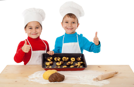 Two kids with baking and ok sign