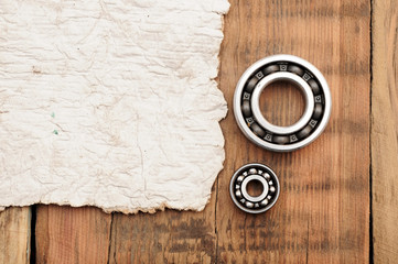 steel ball bearings with old paper on wooden table. space for yo