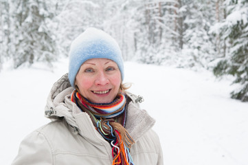 Fototapeta na wymiar Portrait of a middle-aged woman in winter in the forest