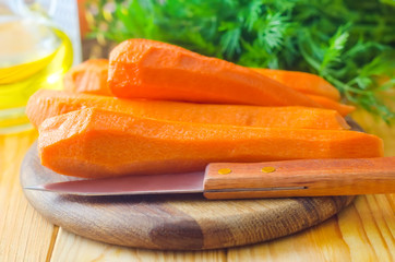 raw carrots and knife on the wooden board