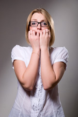 Portrait of a frightened girl in glasses