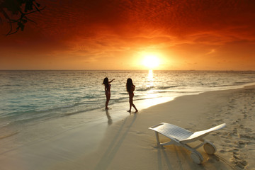 Two women enjoying sunset on beach