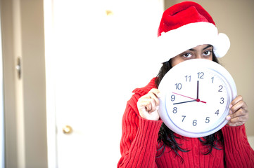 Portrait of beautiful Christmas girl holding clock
