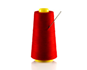 red bobbin with thread and needle