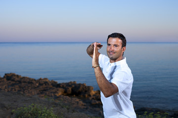 Handsome man on the beach meditating - Tai chi