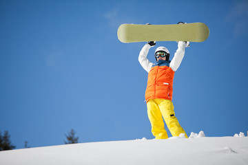 female snowboarder against sun and blue sky