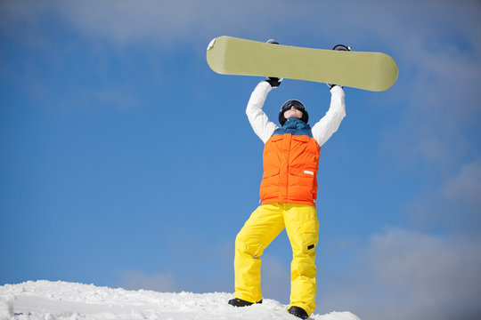 female snowboarder against sun and blue sky
