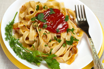 Flat macaroni with ketchup and greens