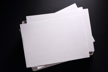 Stack of white paper cards on black