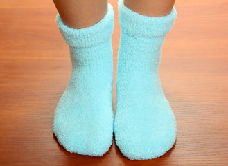 Legs female in blue socks on laminate floor