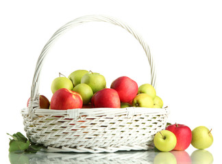 juicy apples with green leaves in basket, isolated on white