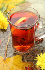 cup of hot drink and autumn leaves, close up
