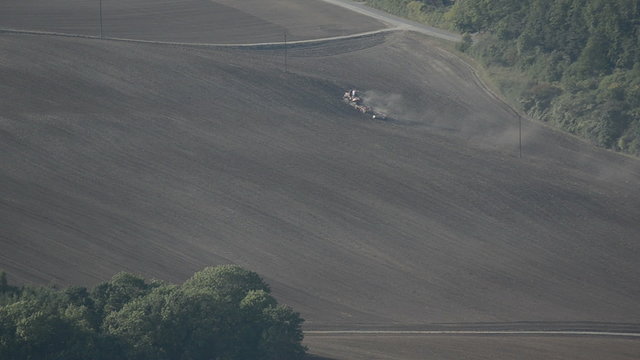 Tractor tilling soil in autumn after harvest