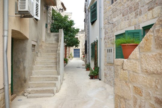 Fototapeta Narrow alley between stone houses, Croatia Dalmatia
