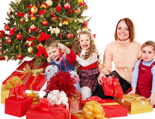 Children with gift box near Christmas tree.