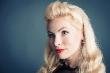 Naklejka premium Beautiful blonde woman close up portrait against dark background