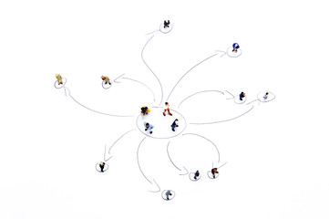 Miniature people on white with some diagrams