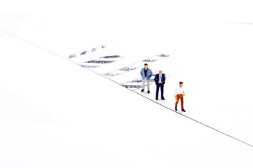 Miniature people on white with some diagrams