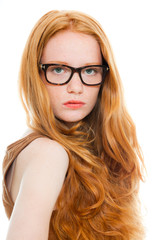 Obraz premium Fashion girl with long red hair wearing black glasses.