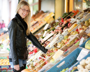 Junge Frau kauft an einem Marktstand ein