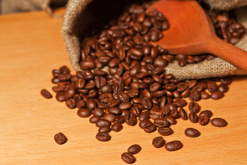 Coffee beans in a sack and wooden spoon still life