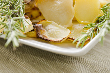 Roasted potatoes with herbs in dish. Selective focus