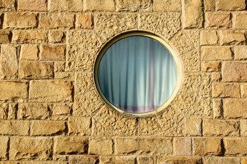 Rundes Fenster an Sandsteinwand