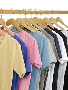 Variety of multicolored casual shirts on wooden hangers,