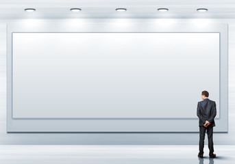 Obraz premium Business person standing near a blank billboard
