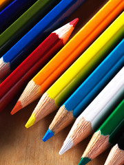 Naklejka premium A detail of colored pencils on a wooden table