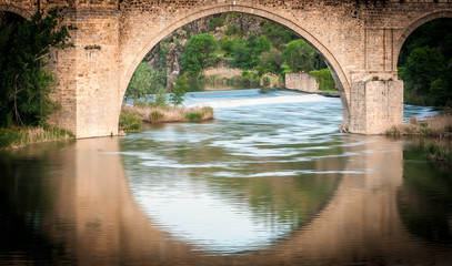 Fototapeta na wymiar Bridge reflects in river of Toledo, Spain, Europe.