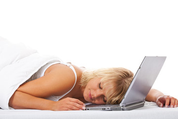 Attraktive Frau schläft mit Laptop im Bett