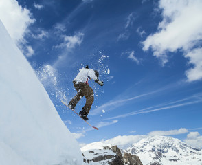 Snowboarder jumping in mountains