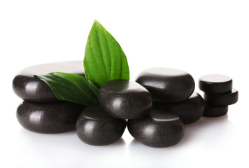 Spa stones and green leaves isolated on white