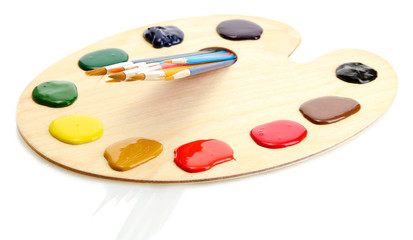 wooden art palette with  paint and brushes.isolated on white