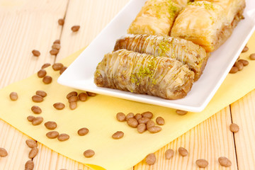 Sweet baklava on plate on wooden background