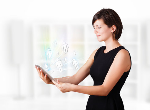 Young woman looking at modern tablet with social icons