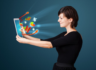 Young woman looking at modern tablet with abstract lights and va