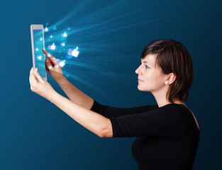 Young woman looking at modern tablet with abstract lights and so