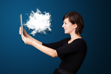 Young woman looking at modern tablet with abstract cloud