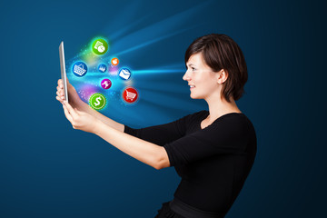 Young woman looking at modern tablet with abstract lights and va