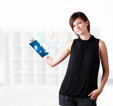 Young woman looking at modern tablet with social icons