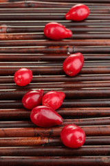 fresh cornel berries on bamboo mat