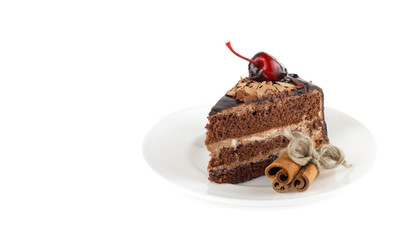 Tasty chocolate cake with cherry on top. With cinnamon sticks.
