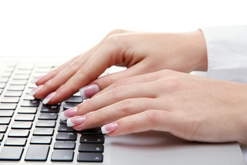 female hands writing on laptot, isolated on white