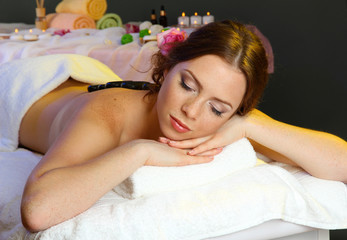 Obraz na płótnie Canvas piękne młoda kobieta w salonie spa z hydromasażem kamieni