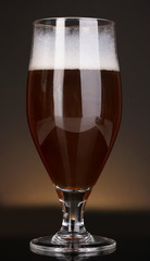 Glass of beer on brown background