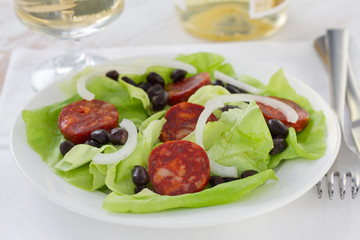 salad with sausages and beans on the white plate