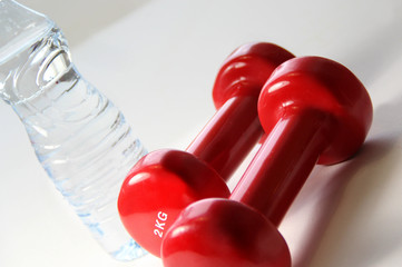 Red dumbbells and bottle of water