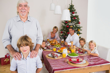 Grandfather and grandson standing beside the dinner table
